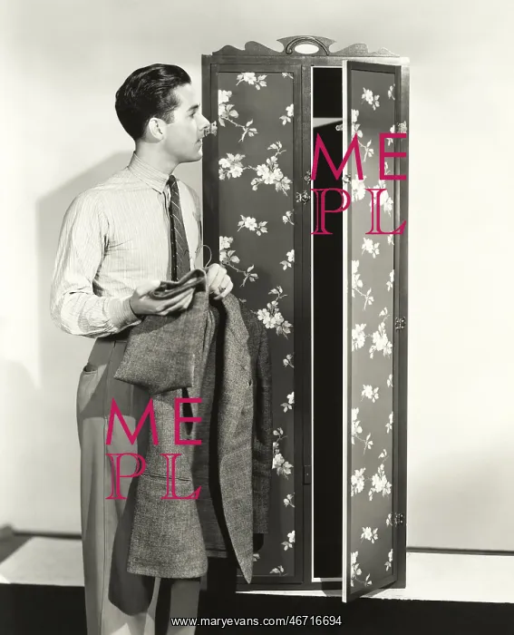  : Man hanging up blazer in armoire