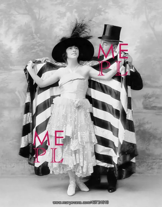 : Man in a top hat helping a woman into a cape : Man in a top hat helping a woman into a cape