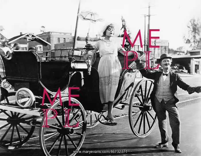 : Man helping a woman get out of a wagon : Man helping a woman get out of a wagon