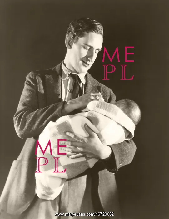 : Man holding baby wrapped in a blanket : Man holding baby wrapped in a blanket