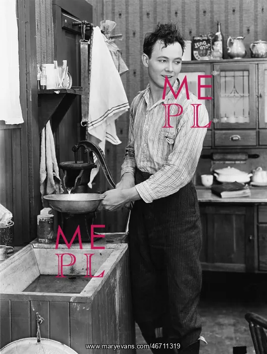  : Man in a kitchen pumping water