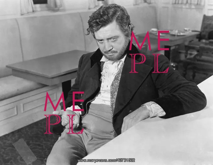 : Man leaning against a counter in a restaurant with : Man leaning against a counter in a restaurant with