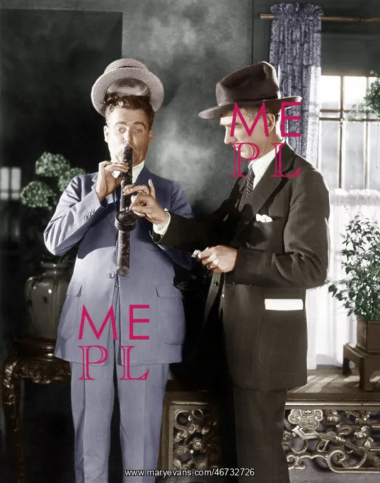 : Man lighting a long pipe while his hat is lifting : Man lighting a long pipe while his hat is lifting