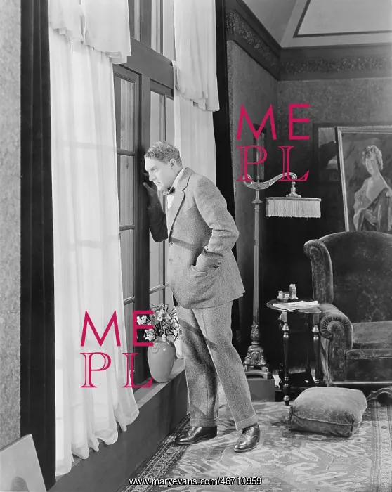 : Man in a living room looking out the window : Man in a living room looking out the window