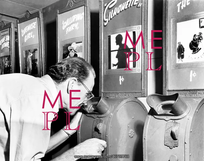 : Man looking into a nickelodeon film machine