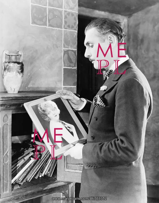 : Man looking at picture of woman : Man looking at picture of woman