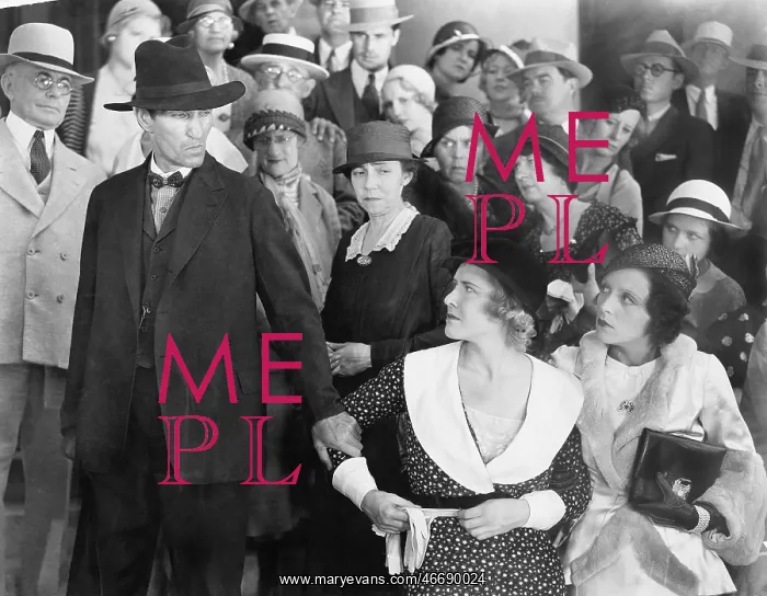 : Man looking at his wife in anger while a group of : Man looking at his wife in anger while a group of