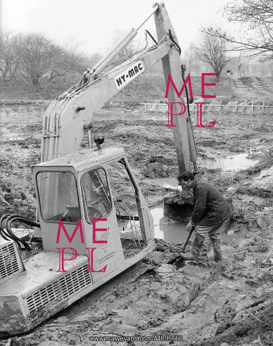 : Man with mechanical digger in a muddy field : Man with mechanical digger in a muddy field