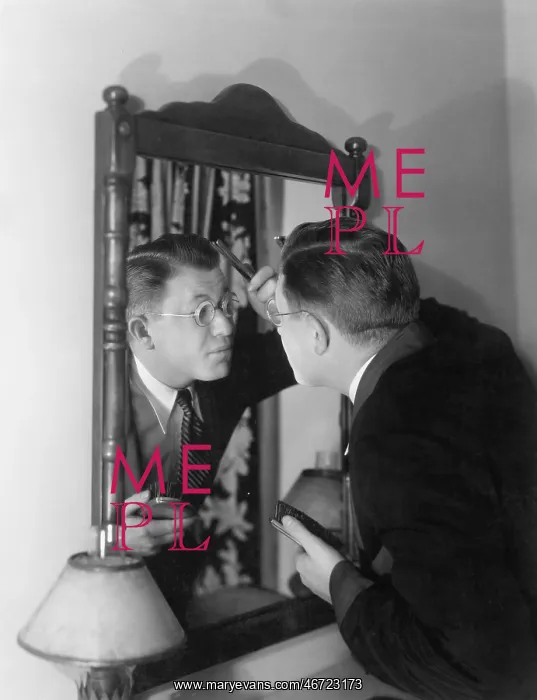 : Man at mirror combing hair : Man at mirror combing hair