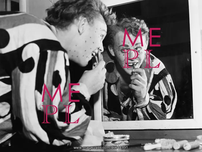  : Man in front of a mirror putting make up on