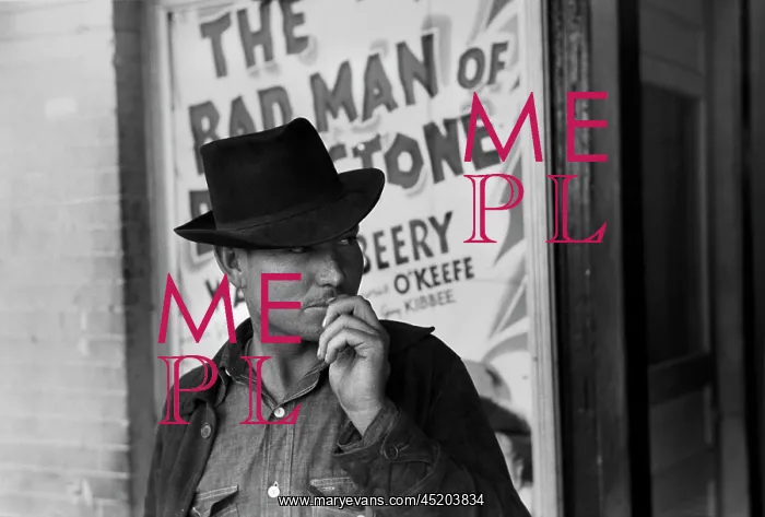 : Man in front of a movie theater playing ? : Man in front of a movie theater playing ?