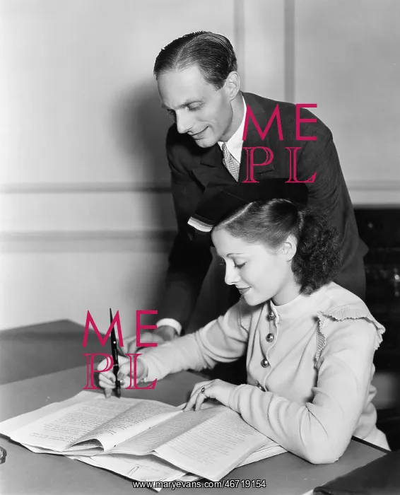 : Man overseeing young womans work : Man overseeing young womans work