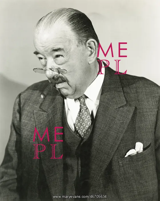  : A man peers over the top of his pince-nez -