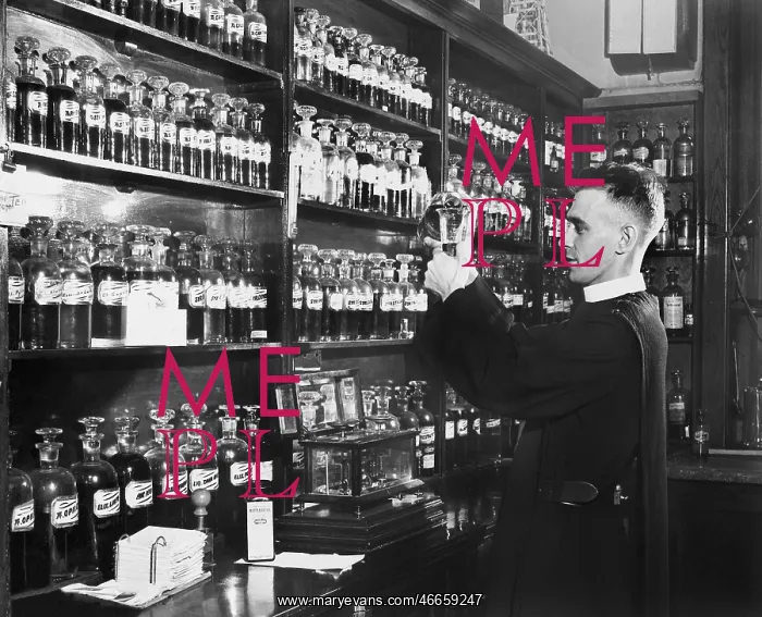 : Man in a pharmacy mixing medicine : Man in a pharmacy mixing medicine