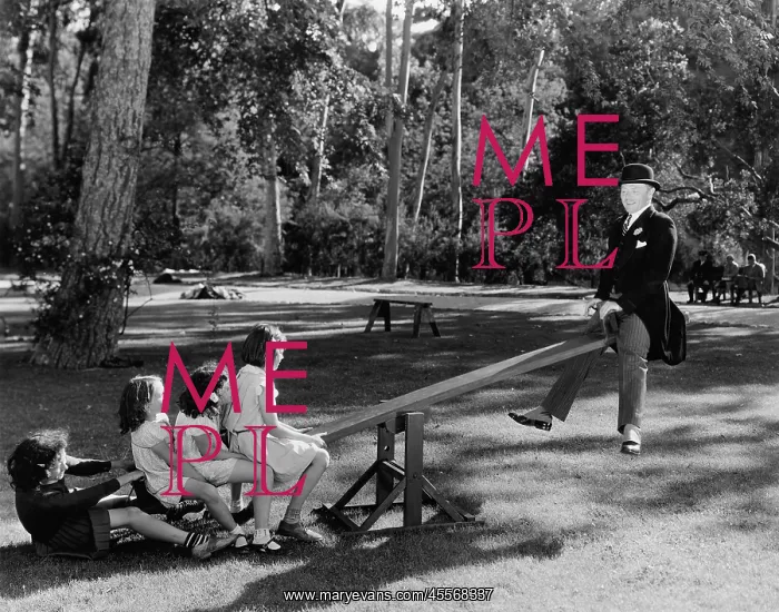 : Man playing with children on a seesaw : Man playing with children on a seesaw
