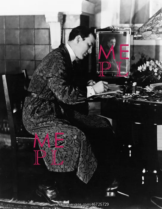 : Man sitting in a chair and writing : Man sitting in a chair and writing