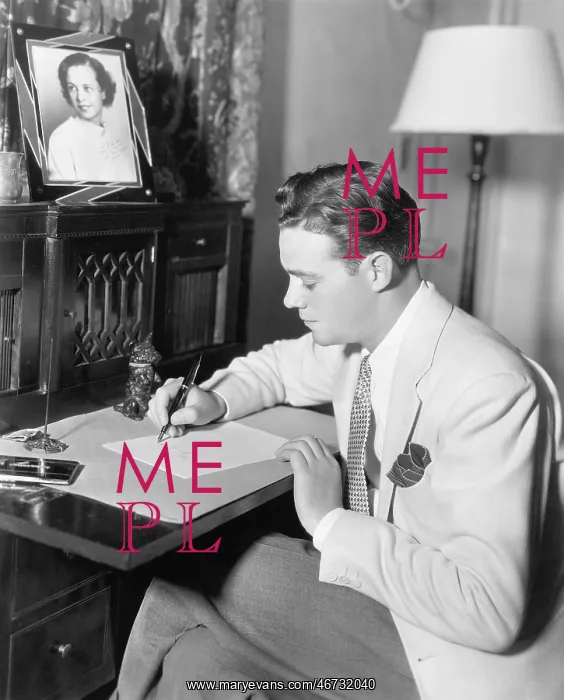 : Man sitting at his desk writing a letter with a : Man sitting at his desk writing a letter with a