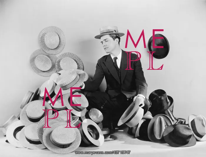 : Man sitting on the floor surrounded by hats : Man sitting on the floor surrounded by hats