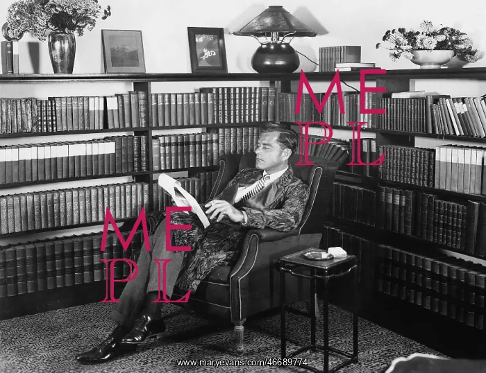  : Man sitting in his library reading a book