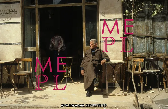 : Man sitting outside a coffee house that ? : Man sitting outside a coffee house that ?