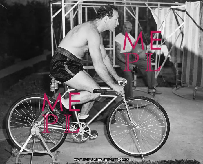 : Man sitting on a stationary bicycle doing exercise : Man sitting on a stationary bicycle doing exercise