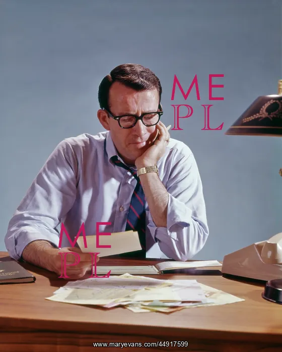  : Man Sitting at Table with Pile of Bills Paperwork and W