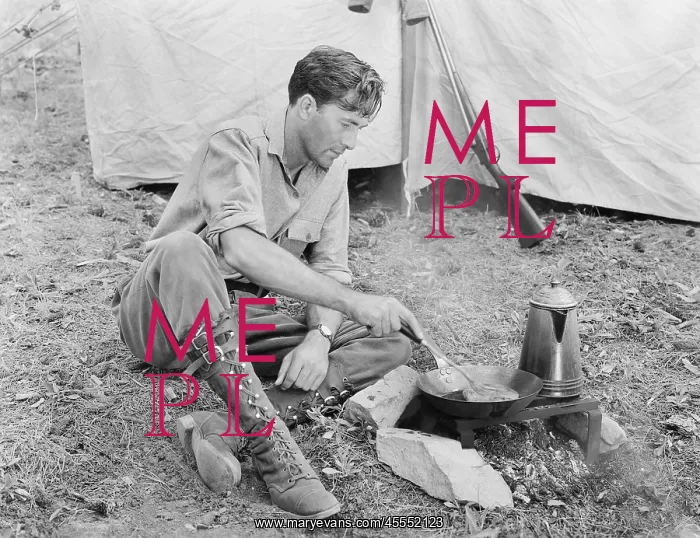 : Man sitting in front of his tent preparing food : Man sitting in front of his tent preparing food