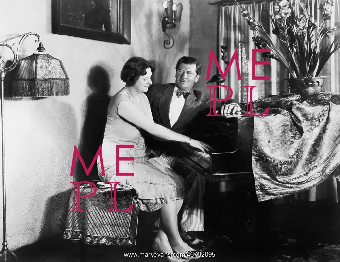 : Man sitting with woman playing the piano : Man sitting with woman playing the piano