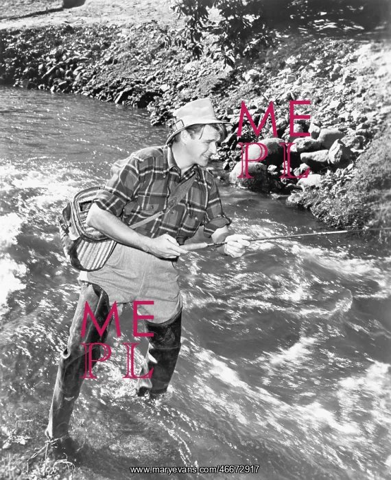  : Man standing in a stream of water fishing