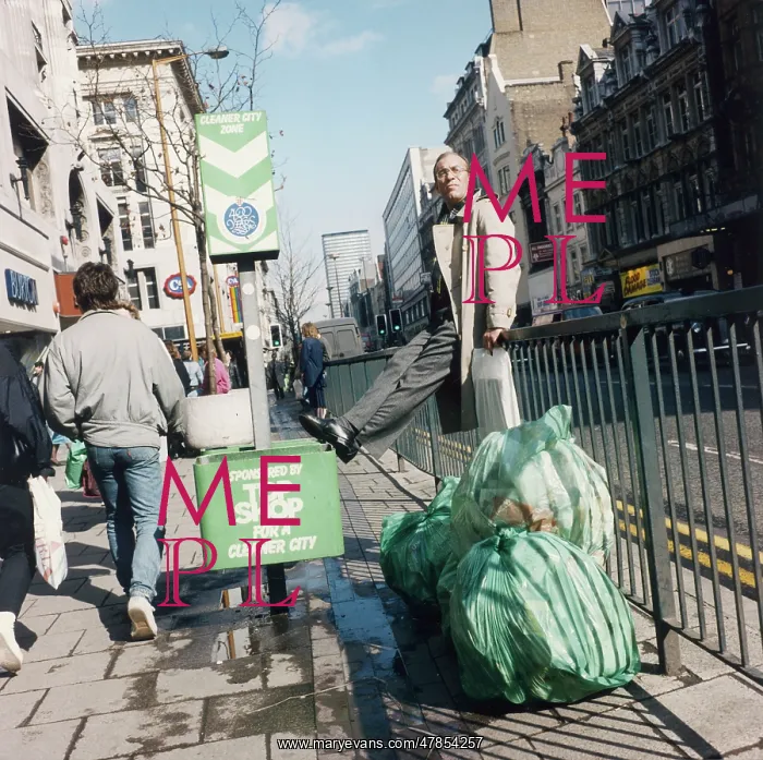 : Man on a streetside fence by some rubbish : Man on a streetside fence by some rubbish
