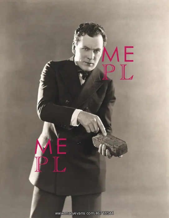 : Man in suit holding a brick : Man in suit holding a brick