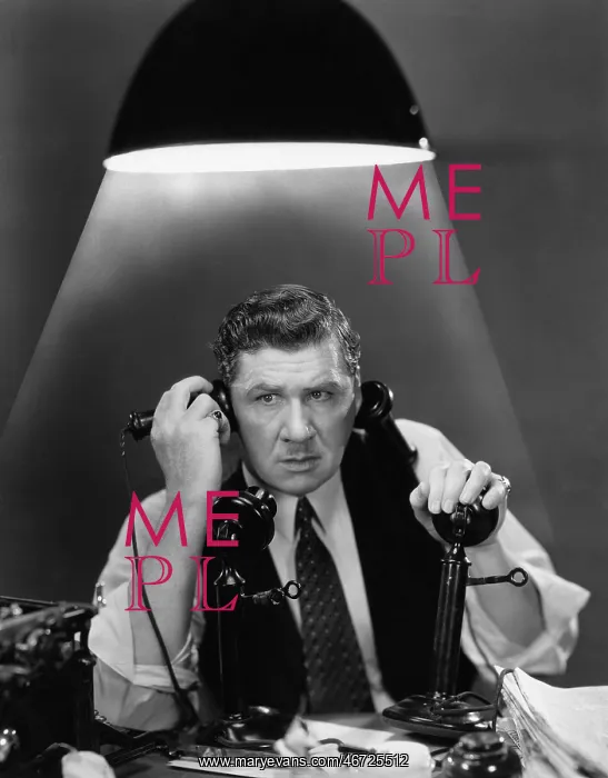 : Man using two telephones : Man using two telephones