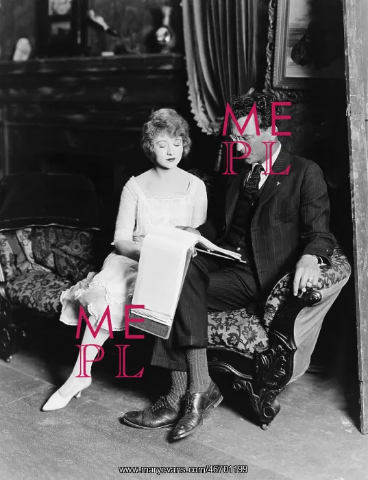 : Man and woman on couch with paperwork : Man and woman on couch with paperwork