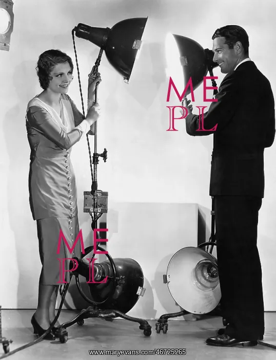 : Man and woman with lights on stands : Man and woman with lights on stands