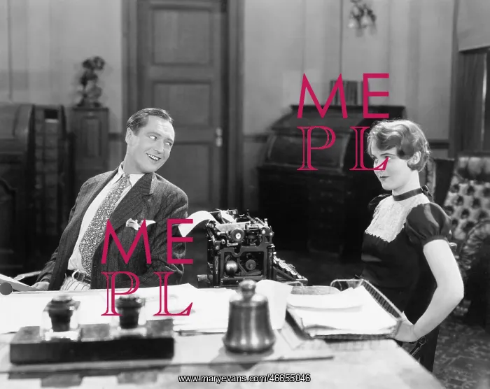 : Man and woman in an office flirting with each other : Man and woman in an office flirting with each other