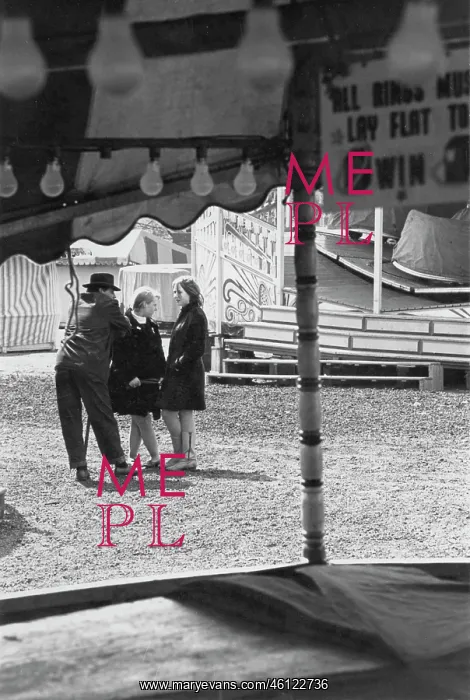 : Man and two women at a closed fairground : Man and two women at a closed fairground