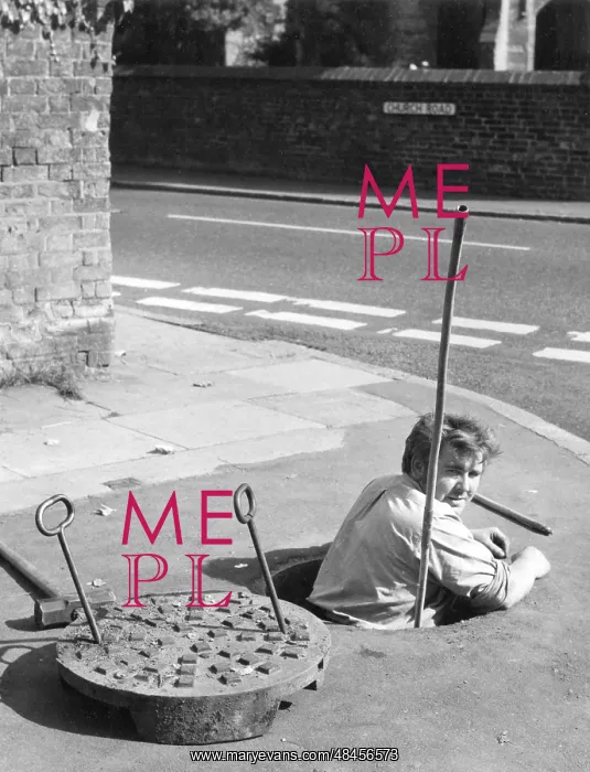 : MANHOLE. A workman emerging from a manhole in Ivinghoe, Buckinghamshire, England : MANHOLE. A workman emerging from a manhole in Ivinghoe, Buckinghamshire, England