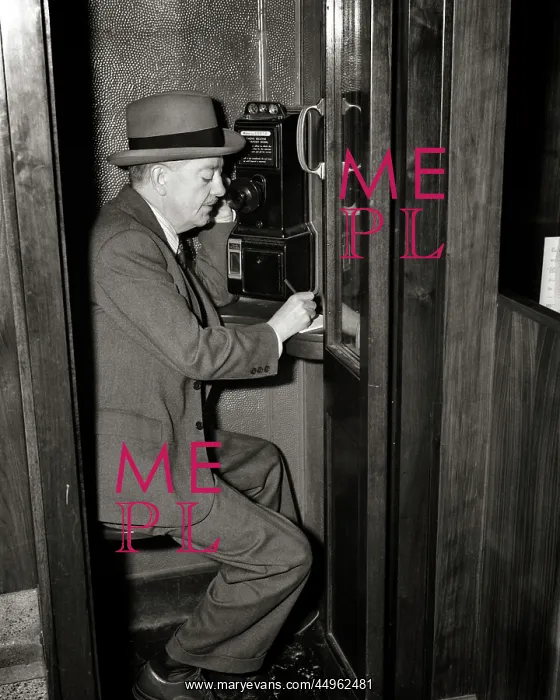: Mature Man Sitting in Pay Telephone Booth Talking : Mature Man Sitting in Pay Telephone Booth Talking