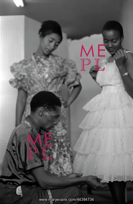 : May 1963 - Model Mojaki looks on as Molefe fiddles : May 1963 - Model Mojaki looks on as Molefe fiddles