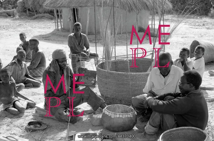 : Mbira player and constructing a large grain basket : Mbira player and constructing a large grain basket