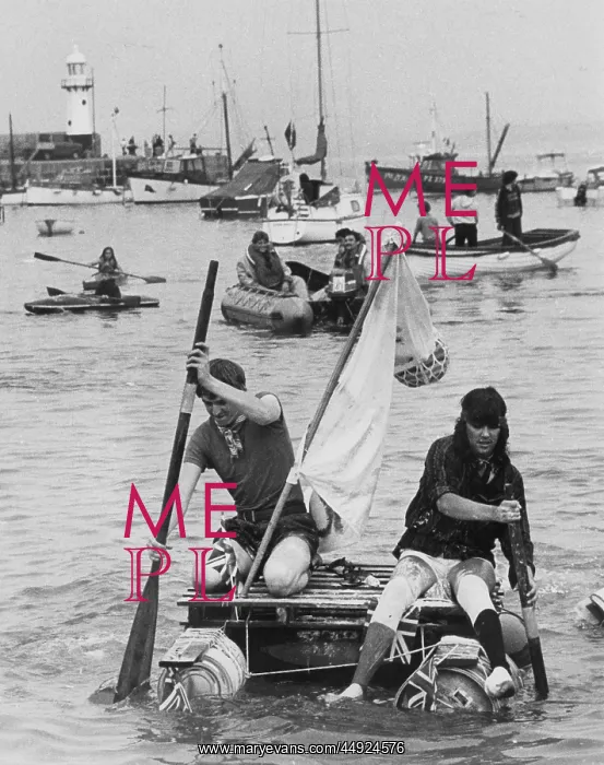 : Two men competing in a raft race, St Ives, Cornwall : Two men competing in a raft race, St Ives, Cornwall