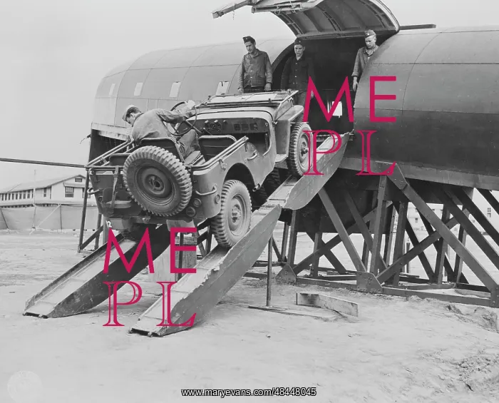 : Men driving a jeep onto a plane at Fort Benning : Men driving a jeep onto a plane at Fort Benning