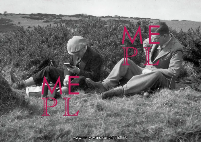 : Two men enjoying a hilltop picnic : Two men enjoying a hilltop picnic