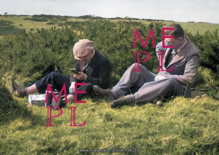: Two men enjoying a hilltop picnic : Two men enjoying a hilltop picnic