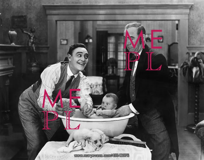 : Two men giving a baby a bath : Two men giving a baby a bath