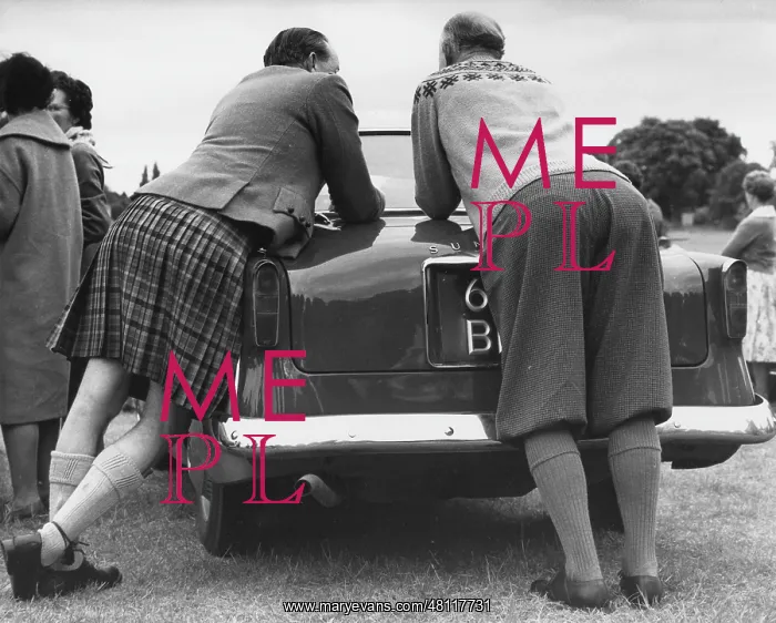 : Two men leaning on a car : Two men leaning on a car