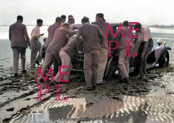 : Men pushing car on wet beach : Men pushing car on wet beach