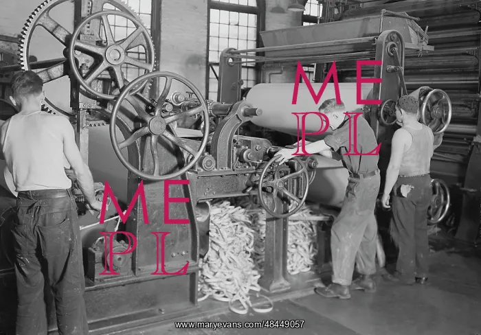 : Men rewinding paper from reel at the American : Men rewinding paper from reel at the American
