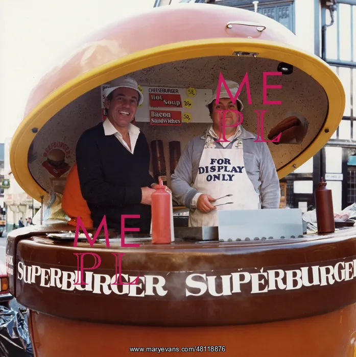 : Two men serving superburgers : Two men serving superburgers
