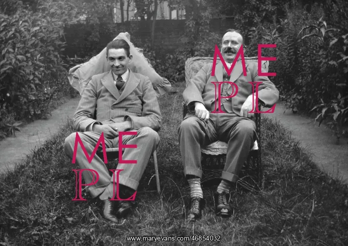 : Two men sitting in a garden : Two men sitting in a garden